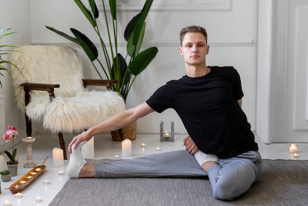 Full shot man doing yoga on mat