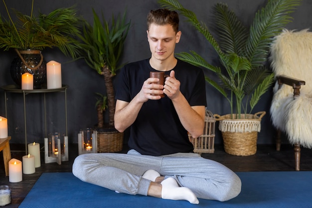 Free photo full shot man doing yoga on mat