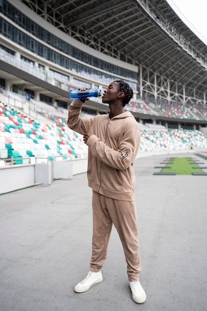 Free photo full shot man drinking water