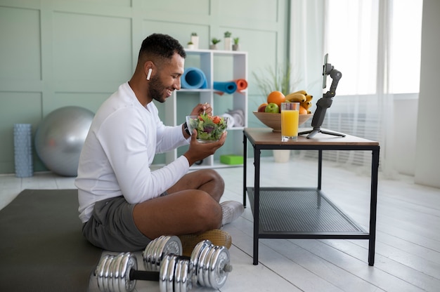 full shot man eating eating salad