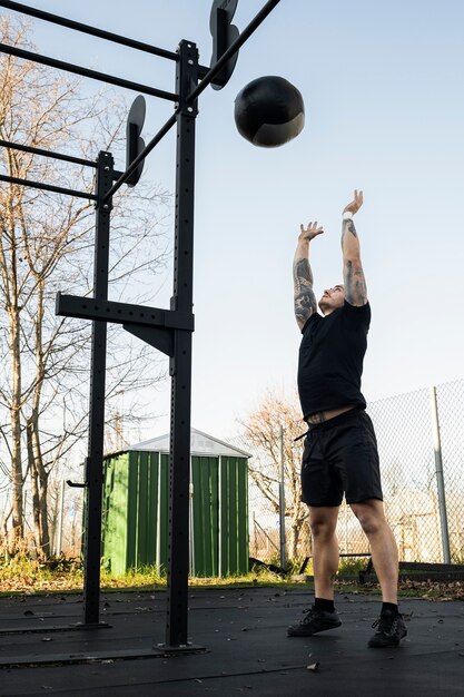 Full shot man exercising with ball