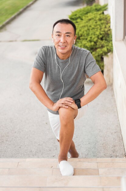 Full shot man exercising with earphones