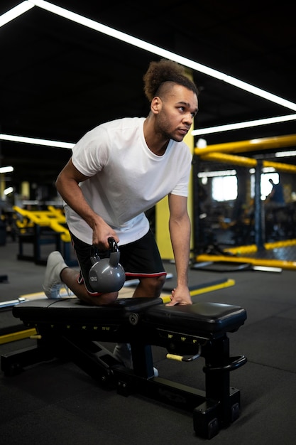 Full shot man exercising with kettlebell