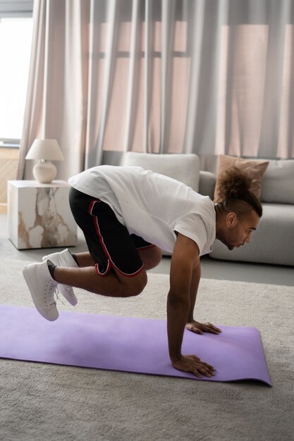 Full shot man exercising on yoga mat