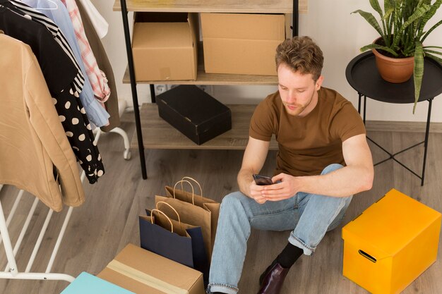 Full shot man on floor with smartphone