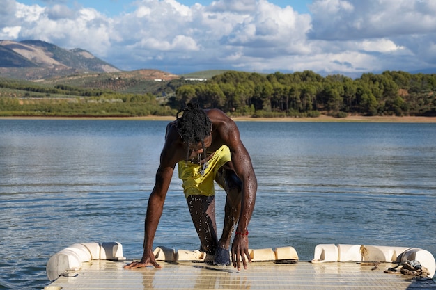 Full shot man getting out of lake