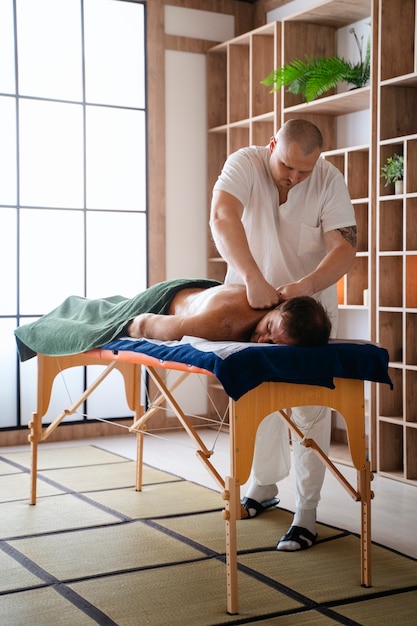 Full shot man getting professional massage