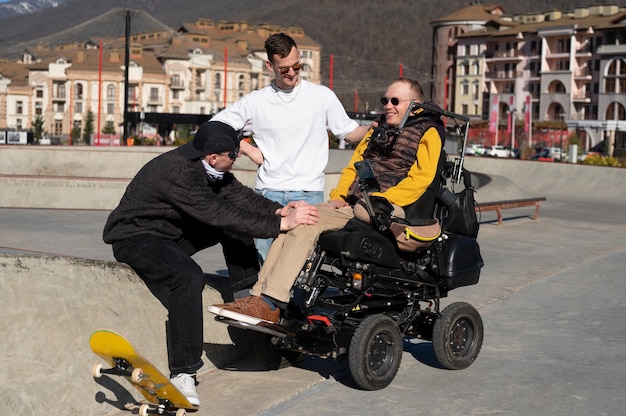 Foto gratuita uomo a tutto campo che aiuta un amico disabile