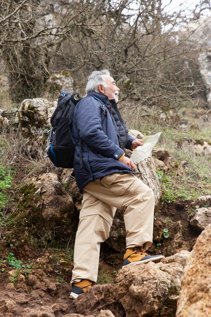 Full shot man hiking with map