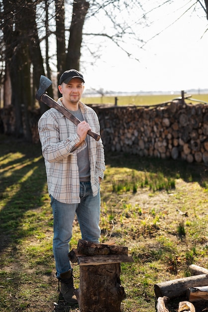 Full shot man holding axe outdoors