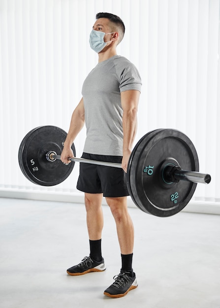 Full shot man holding bar with dumbbells