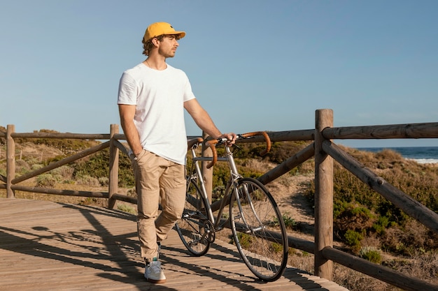 Free photo full shot man holding bicycle