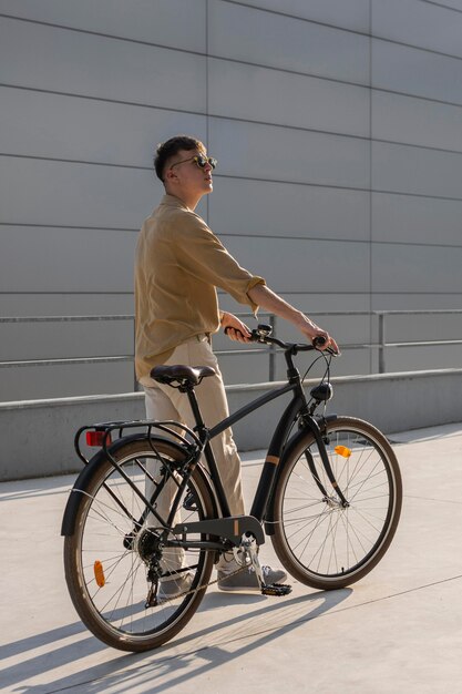 Full shot man holding bike