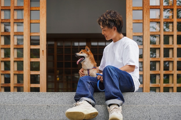 Free photo full shot man holding cute dog