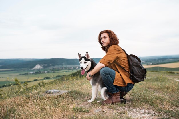 屋外で犬を保持しているフルショットの男