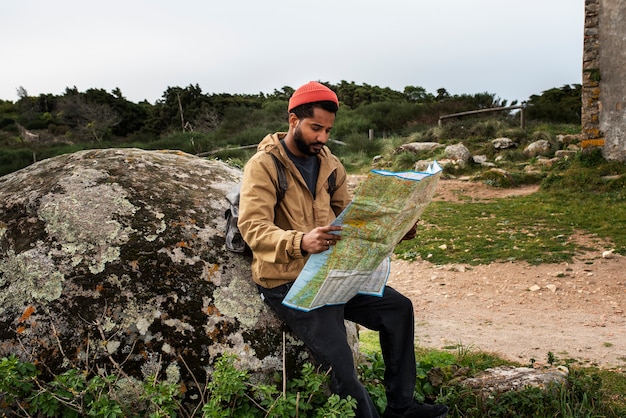 Free photo full shot man holding map