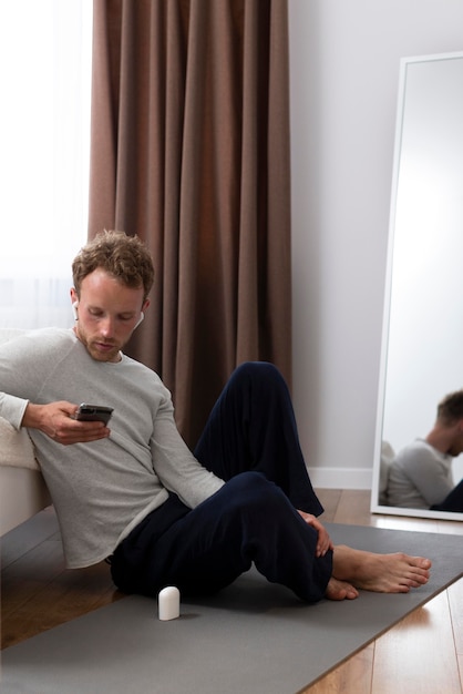 Full shot man holding smartphone