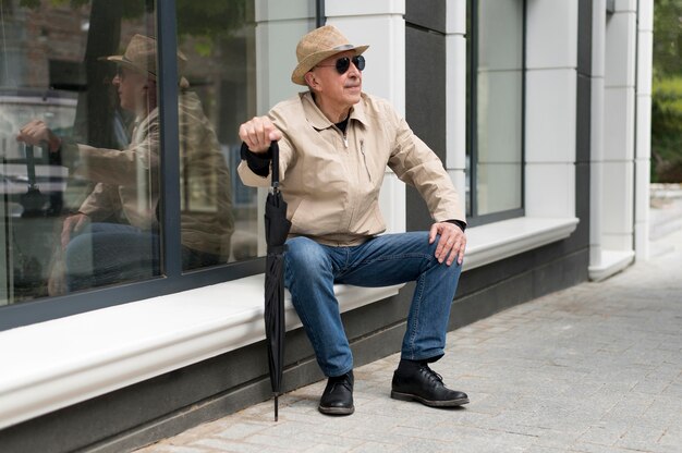 Full shot man holding umbrella