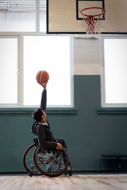 Free photo full shot man holding up basketball