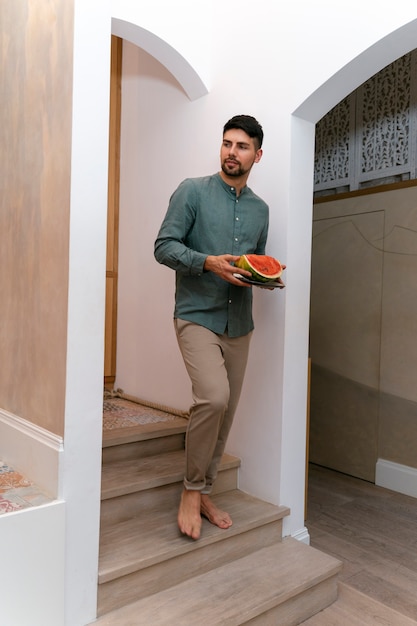 Full shot man holding watermelon slice