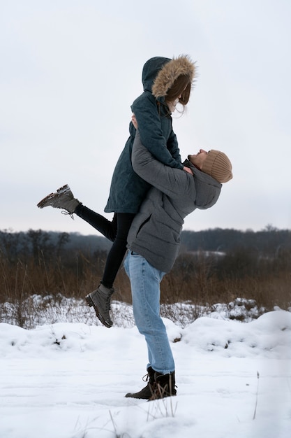 Free photo full shot man holding woman up