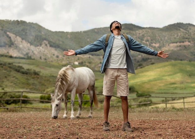 Foto gratuita uomo e cavallo pieno del colpo all'aperto