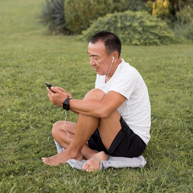 スマートフォンを見ているフルショットの男