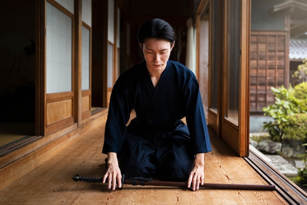 Full shot man meditating indoors