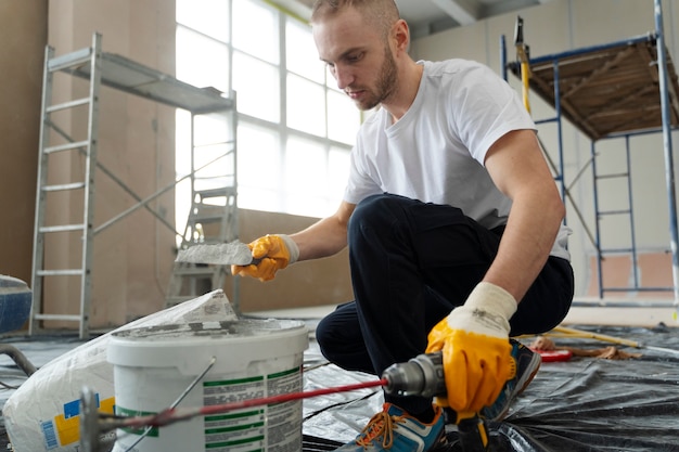 Free photo full shot man mixing construction composition