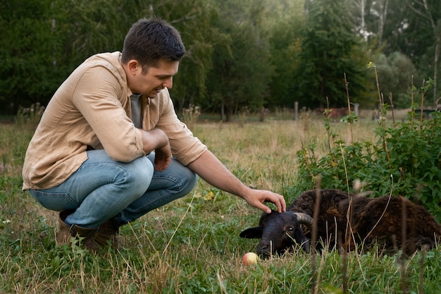 Free photo full shot man petting sheep