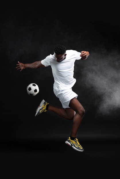 Foto gratuita uomo a tutto campo che gioca a calcio