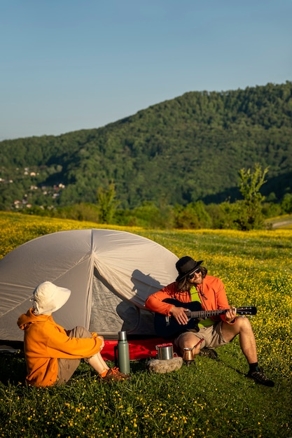 Foto gratuita uomo a tutto campo che suona la chitarra in natura