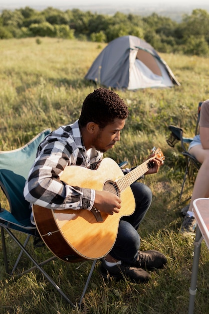 Foto gratuita uomo a tutto campo che suona la chitarra