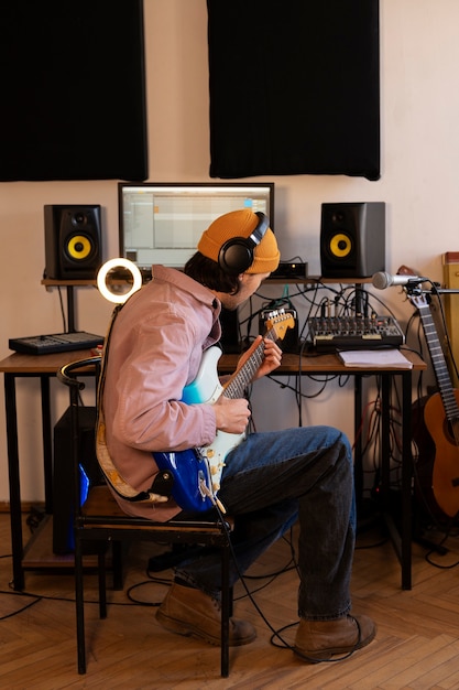 Full shot man playing the guitar