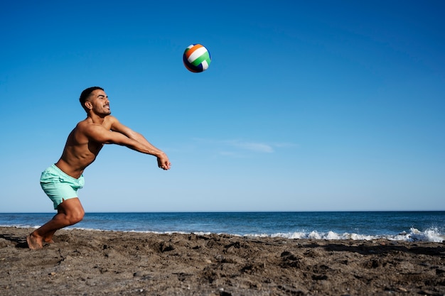 Free photo full shot man playing volleyball