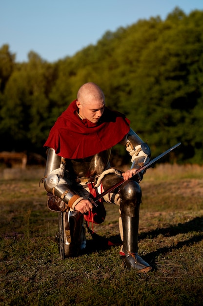 Full shot man posing as a medieval soldier