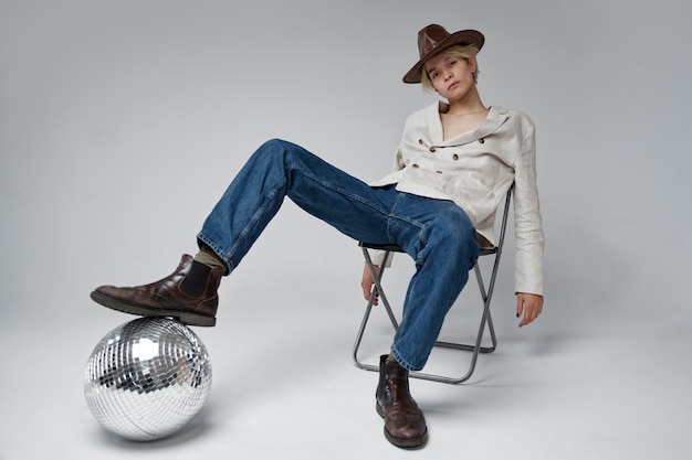 Full shot man posing with disco ball at studio