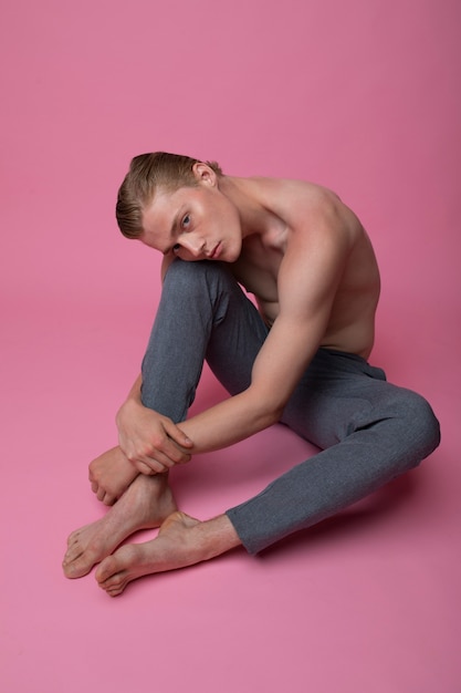 Full shot man posing with pink background