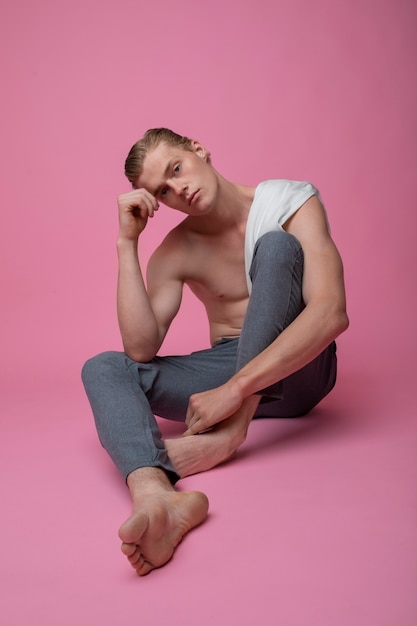 Full shot man posing with pink background