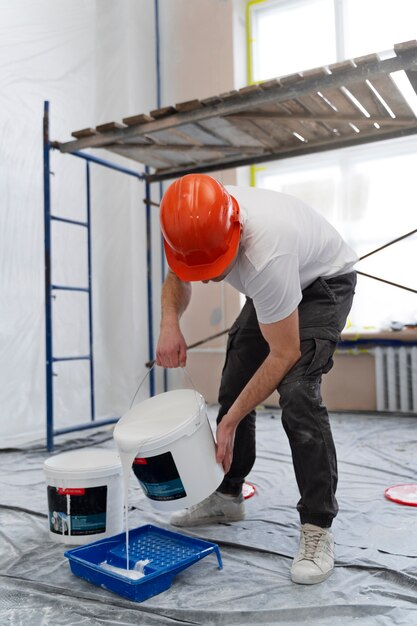 Full shot man pouring paint