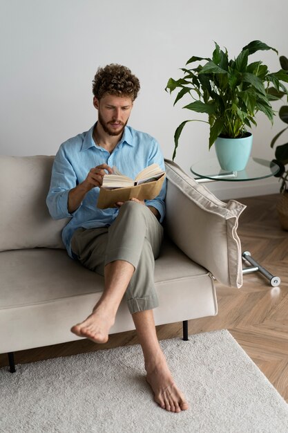 家で本を読んでいるフルショットの男