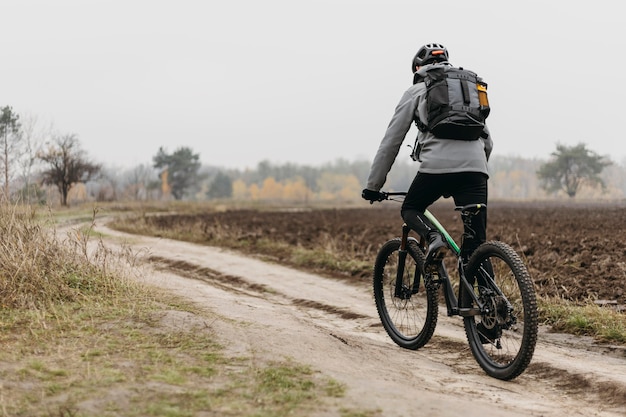 Free photo full shot of man riding a bike