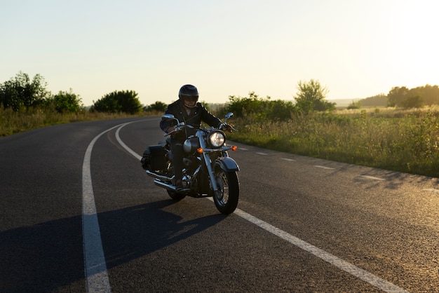 Foto gratuita uomo a figura intera in sella a una moto