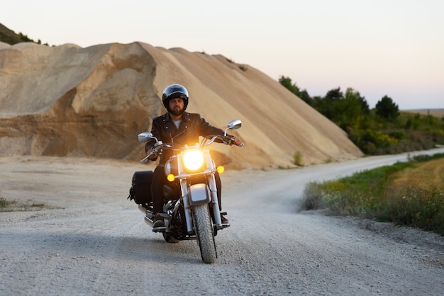 Foto gratuita uomo a figura intera in sella a una moto