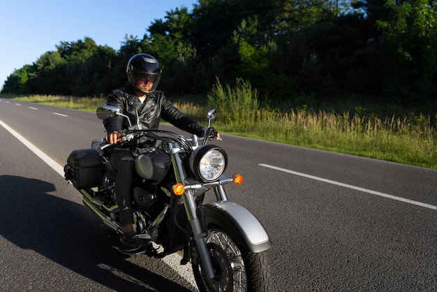 Foto gratuita uomo a figura intera in sella a una moto