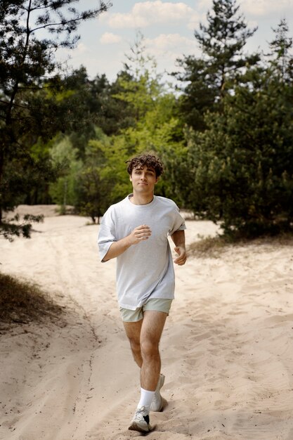 Full shot man running on sand