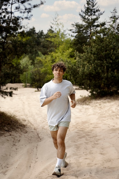 Full shot man running on sand