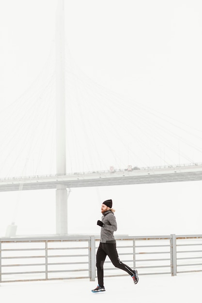 Uomo pieno del colpo che corre in inverno