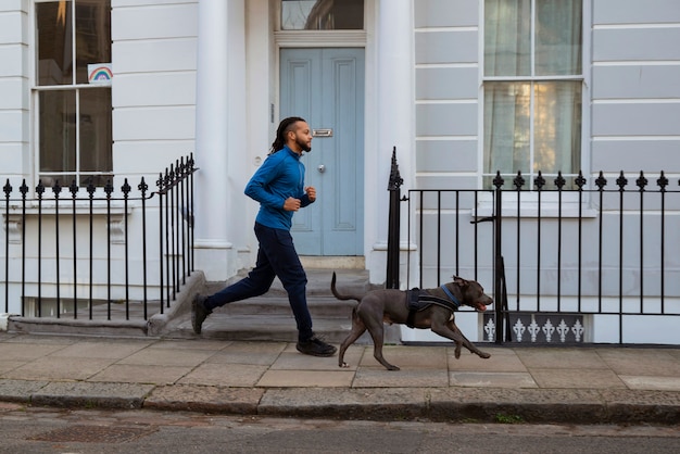 Free photo full shot man running with dog outdoors