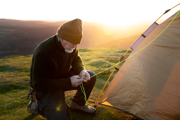 Full shot man setting up a tent